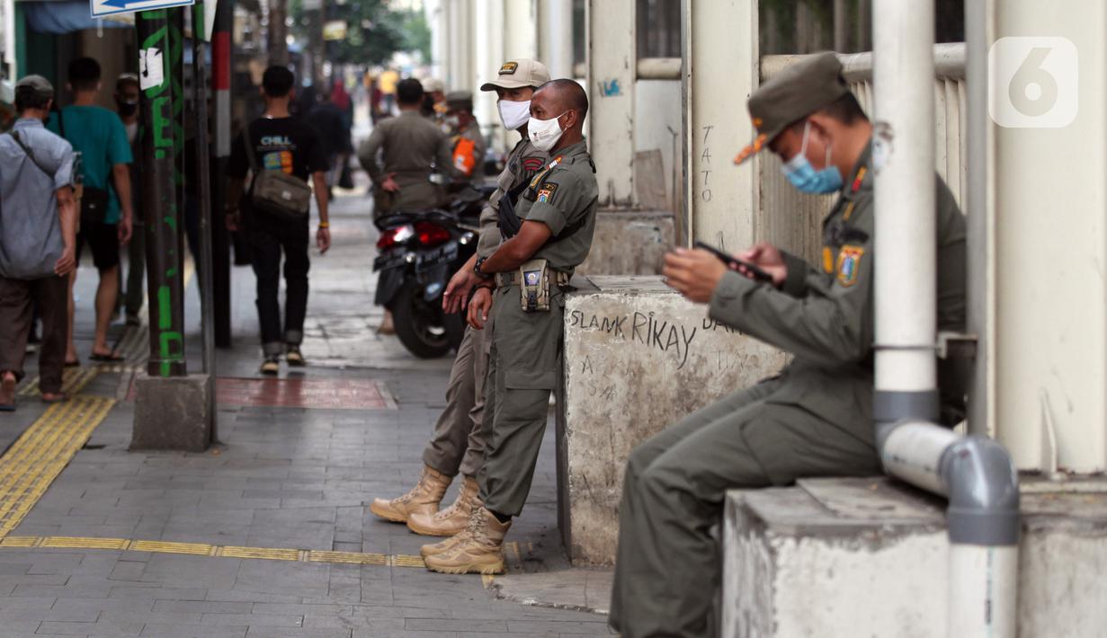 Petugas Satpop PP berjaga di kawasan Pasar Tanah Abang, Jakarta, Rabu (7/7/2021). Satpol PP melakukan penjagaan di seluruh Pasar Tanah Abang mengantisipasi pedagang yang membandel tetap berjualan saat diberlakukannya PPKM Darurat. (Liputan6.com/Angga Yuniar)