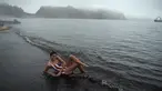 Wisatawan menikmati air panas di danau kawah Pulau Deception, Antartika, 6 Maret 2016. Danau air panas itu berasal dari kaldera gunung berapi aktif yang rusak pada tahun 1967 dan 1969 hingga membentuk danau kawah berair panas. (AFP PHOTO/Eitan Abramovich)