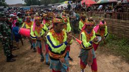Orang-orang memainkan alat musik saat mereka mengambil banteng untuk parade selama kompetisi balap banteng Karapan Sapi di Bangkalan, pulau Madura, Jawa Timur, Minggu (16/10/2022). Lomba karapan sapi yang memperebutkan Piala Presiden itu diikuti 24 pasang sapi dari sejumlah daerah di Madura. (Juni Kriswanto/AFP)