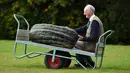 Peter Glazebrook berpose dengan marrow seberat 66,8 kg yang berhasil memenangkan kelasnya ketika mengikuti kompetisi sayuran dan buah raksasa pada hari pertama Flower Show Autumn Harrogate, di Harrogate, Inggris, Jumat (15/9). (OLI SCARFF/AFP)