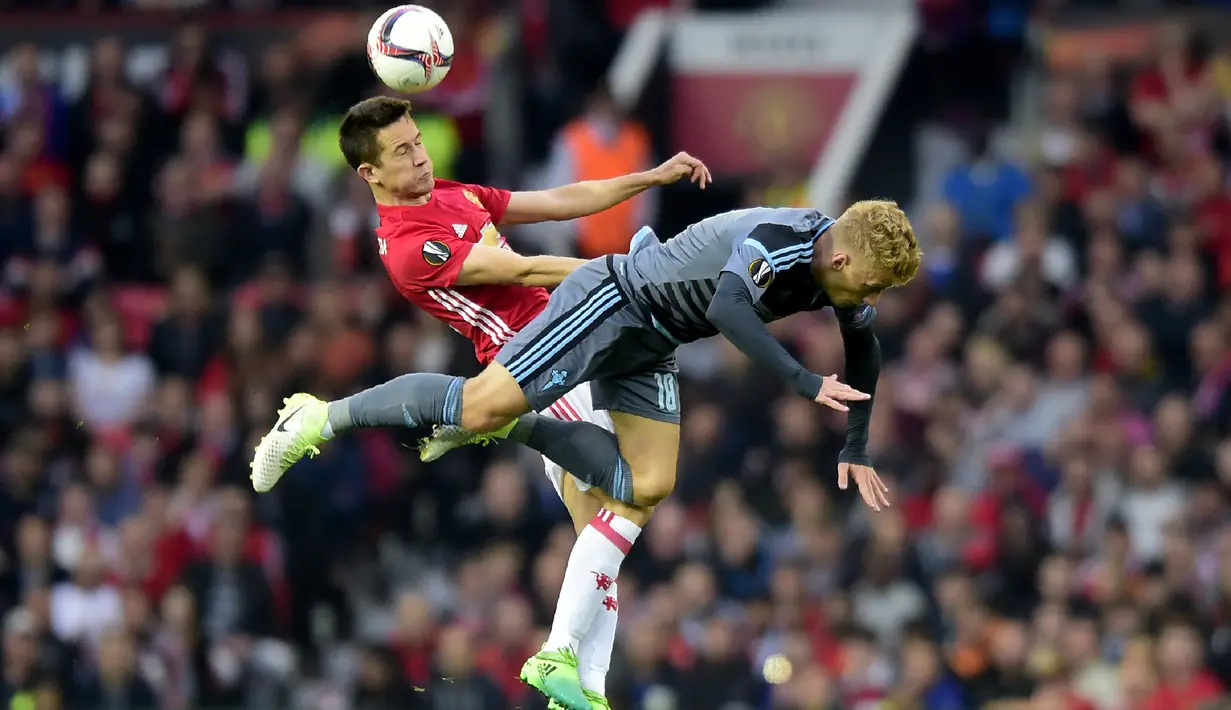 Gelandang MU, Ander Herrera berebut bola udara dengan bek Celta Vigo, Daniel Wass saat bertanding pada leg kedua Liga Europa di stadion Old Trafford, Inggris,(11/5). MU melaju ke final usai menang dengan aggregat 2-1. (AFP Photo/Miguel Riopa)