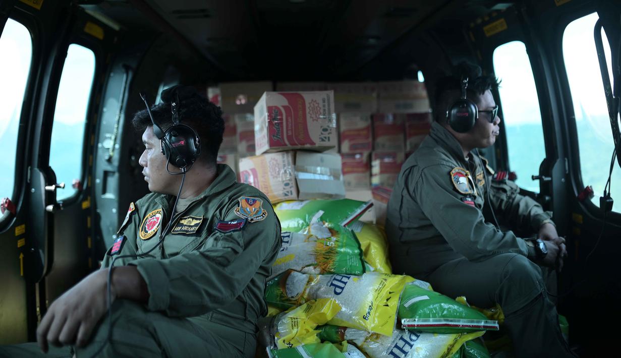 Distribusi bantuan sebagian besar dilakukan melalui jalur udara menggunakan helikopter untuk menjangkau daerah-daerah yang masih terisolasi. Tampak dalam foto, personel TNI AU duduk di dalam helikopter untuk mendistribusikan bantuan ke daerah terdampak banjir di Aceh Tengah, Sabtu 6 Desember 2025. (AP Photo/Reza Saifullah)