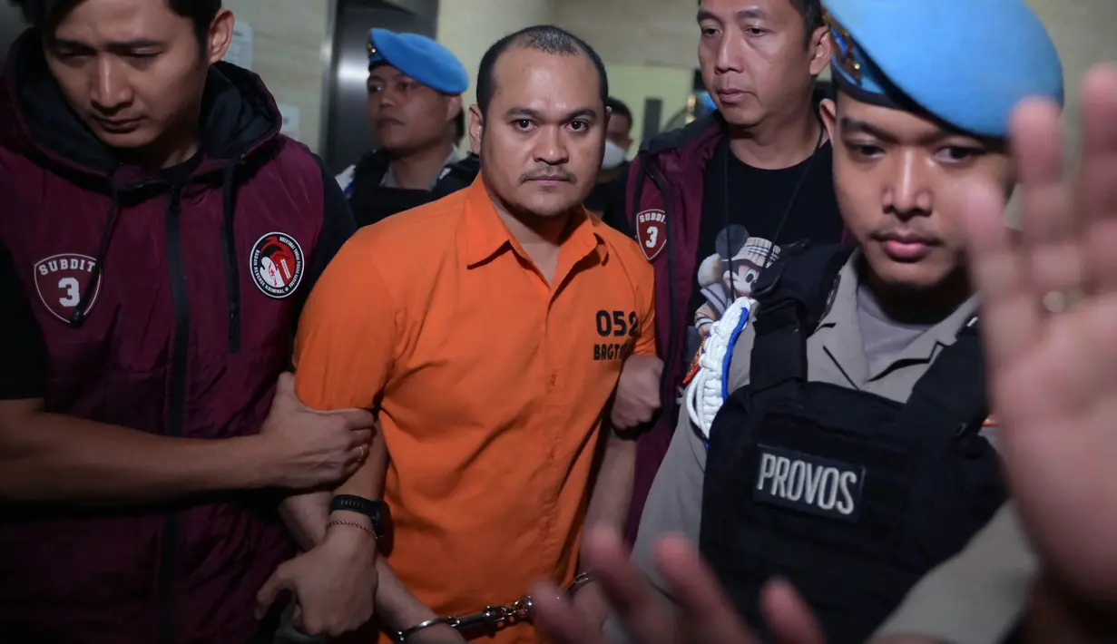 Petugas Badan Reserse dan Kriminal (Bareskrim) Mabes Polri mengawal ketat Chaowalit Thongduang (tengah) saat akan dibawa menuju Bandara Soekarno-Hatta untuk diekstradisi ke negara asalnya, Jakarta pada tanggal 4 Juni 2024. (Bay ISMOYO/AFP)
