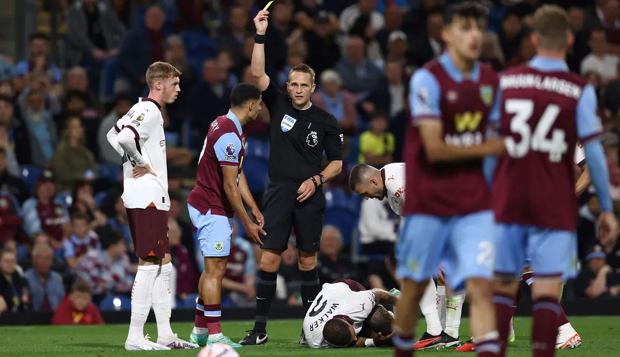 Reaksi kecewa striker Burnley, Anass Zaroury (kedua kiri) setelah menerima kartu kuning usai menjatuhkan Kyle Walker pada laga pekan pertama Liga Inggris 2023/2024 di Turf Moor, Burnley (11/8/2023). Partai Burnley kontra Manchester City juga menghasilkan kartu merah pertama di Liga Inggris 2023/2024 yang didapatkan sayap kiri Burnley, Anass Zaroury. Tekel kerasnya terhadap Kyle Walker pada masa injury yang sempat berbuah kartu kuning akhirnya dikoreksi menjadi kartu merah langsung lewat tinjauan VAR. (AFP/Darren Staples)