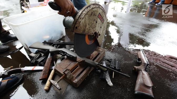 Senjata api dimusnahkan menggunakan mesin pemotong besi di Kejaksaan Negeri Jakarta Timur, Rabu (24/4). Barang bukti yang dimusnahkan berupa senjata api, senjata tajam dan beberapa jenis narkoba hasil pengungkapan kasus hukum di wilayah Jakarta Timur periode 2018-2019. (merdeka.com/Imam Buhori)