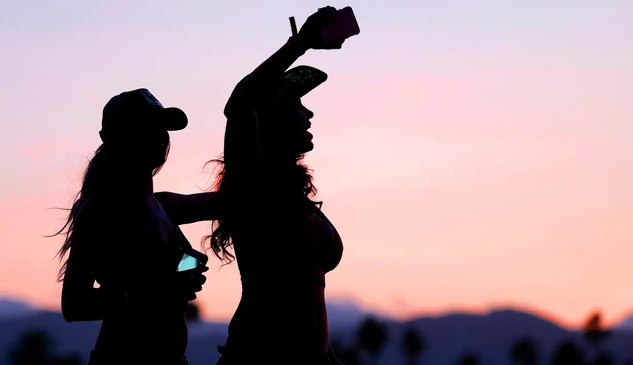 Dua wanita seksi bernyanyi dan berjoged menggunakan topi koboi saat menghadiri Festival musik Country Stagecoach di Empire Polo Club di Indio, California, 29 April 2016. (AFP PHOTO/Jason Kempin)