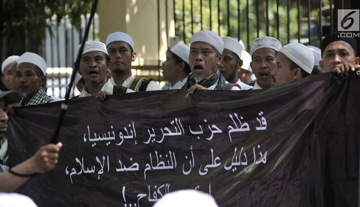 Massa dari HTI menggelar spanduk saat menunggu sidang putusan gugatan di luar gedung PTUN, Jakarta, Senin (7/5). Usai sujud syukur, massa mendengarkan orasi dari pimpinan HTI. (Merdeka.com/Iqbal S Nugroho)