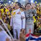 Raja Maha Vajiralongkorn dan Ratu Suthida melambaikan tangan ke pendukungnya di Bangkok, Thailand, Minggu (1/11/2020). Di bawah tekanan yang meningkat dari pengunjuk rasa yang menuntut reformasi pada monarki, Raja dan Ratu Thailand bertemu dengan ribuan pendukungnya. (AP Photo/Wason Wanichakorn)