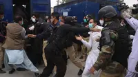 Polisi huru hara membubarkan aksi demonstrasi dari dokter dan tenaga medis di Pakistan, Senin (6/4/2020). Para dokter mengatakan pemerintah telah gagal memberikan pasokan APD yang dijanjikan. (AP Photo/Arshad Butt)