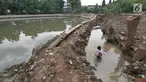 Seorang anak mencari ikan di situ Pedongkelan, Cimanggis, Depok, Rabu (28/11). Proyek normalisasi Situ Pedongkelan mengakibatkan keberadaan tumpukan lumpur bercampur sampah yang mengepung areal permukiman warga. (Liputan6.com/Herman Zakharia)