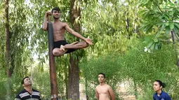 Seorang pesenam saat mengikuti sesi latihan Mallakhamb di CN Sports Academy di Ahmedabad, India, Sabtu (10/6). Mallakhamb adalah olahraga tradisional India yang sudah ada sejak abad ke-12. (AFP PHOTO / Sam PANTHAKY)