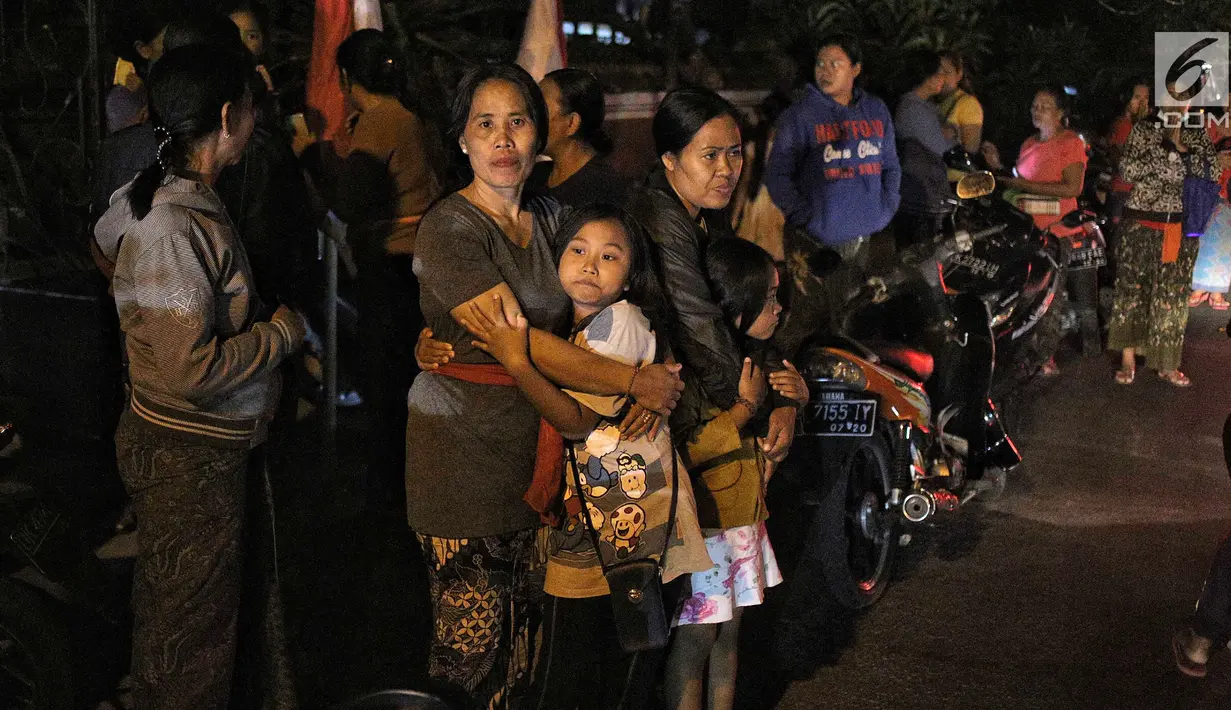 Warga berhamburan keluar rumah saat gempa berkekuatan 7 SR di Lombok dirasakan di kawasan Nusa Dua Bali, Minggu (5/8). Gempa berada pada titik 8.25 LS, 116.49 BT, atau sekitar 27 km Timur Laut Lombok Utara, NTB. (Liputan6.com/Faizal Fanani)