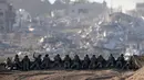 Sebuah foto yang diambil di Israel selatan dekat perbatasan dengan Jalur Gaza pada 11 Desember 2023, menunjukkan tentara Israel berjaga di sebuah bukit yang menghadap ke Gaza utara, di tengah pertempuran yang terus berlanjut antara Israel dan kelompok militan Hamas. (Menahem KAHANA/AFP)