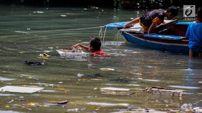 Anak-anak bermain di antara sampah kiriman yang mengotori perairan Kepulauan Seribu di sekitar Pulau Pari dan Pulau Pramuka, Rabu (28/11). Sampah berasal dari wilayah luar Jakarta yang terbawa angin hingga ke perairan Jakarta. (Liputan6.com/Faizal Fanani)