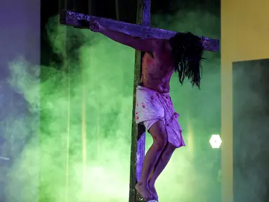 Pria pemeran Yesus Kristus disalib selama prosesi 'Tablo' memperingati Jumat Agung di Gereja Maria Bunda Karmel, Jakarta, Jumat (18/4). Prosesi ini menggambarkan peristiwa yang dialami Yesus menjelang dan saat penyaliban. (Liputan6.com/Faizal Fanani)