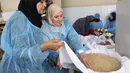 Para wanita membuat maftoul atau couscous di Khan Yunis, Jalur Gaza, Palestina, 10 Januari 2022. Saat musim dingin di Palestina, maftoul menjadi hidangan yang sangat dicari. (SAID KHATIB/AFP)