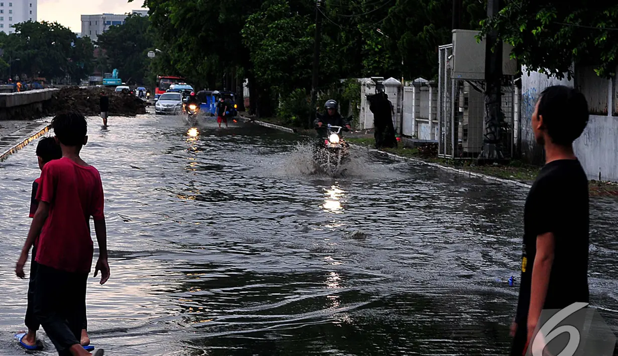 Sejumlah pengendara motor nekat melintas jalan yang terkena banjir di kawasan Cempaka Putih Tengah, Jakarta Pusat, Jumat (5/12/2014). (Liputan6.com/Johan Tallo)