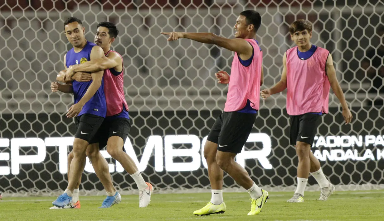 Pemain Timnas Malaysia, Norshahrul Idlan Talaha bercanda dengan Brendan Gan, saat latihan jelang laga kualifikasi Piala Dunia di SUGBK, Jakarta, Rabu (4/9). Malaysia akan berhadapan dengan Indonesia. (Bola.com/M Iqbal Ichsan)