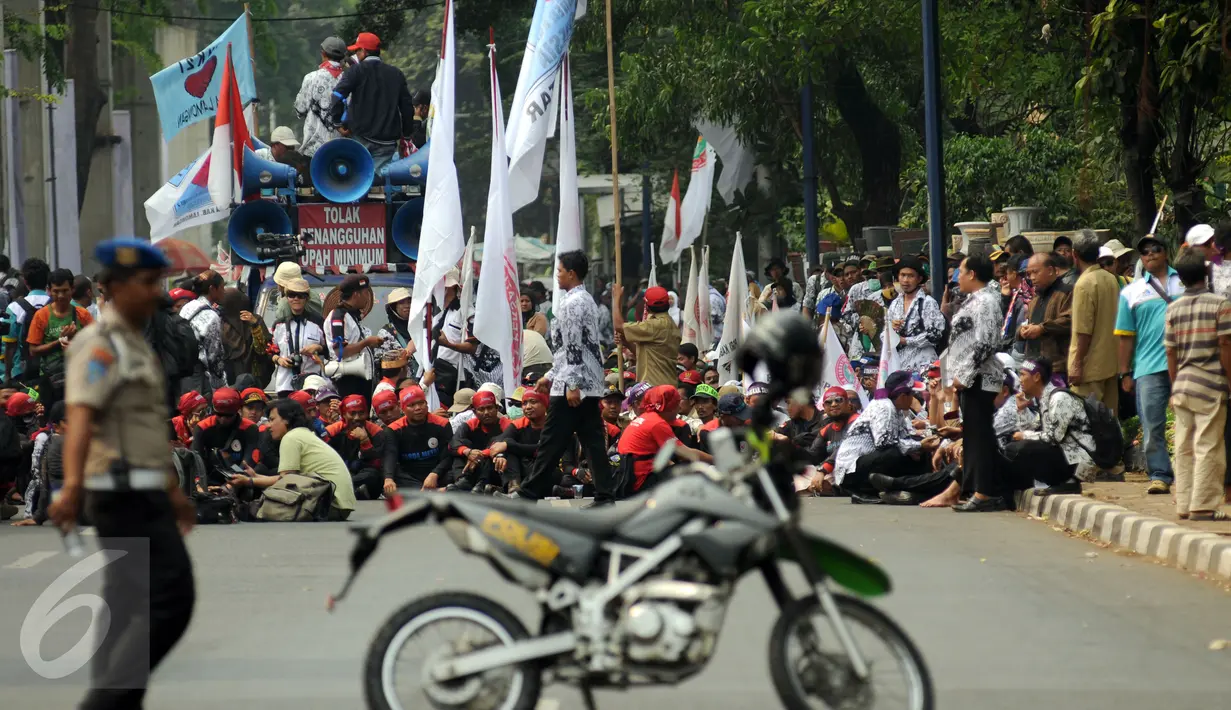 Ribuan guru honorer dari berbagai wilayah duduk di ruas jalan Asia Afrika Jakarta, Selasa (15/9/2015). Aksi para guru honorer terpaksa dihentikan oleh pihak kepolisian karena mengganggu pengguna jalan. (Liputan6.com/Helmi Fithriansyah)
