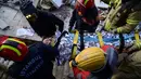 Tim penyelamat mengevakuasi seorang gadis Suriah berusia 12 tahun, Cudi, dari puing-puing bangunan yang hancur di Hatay, Turki, setelah gempa berkekuatan 7,8 melanda tenggara negara itu, Minggu (12/2/2023). Pada jam ke-147gempa di Hatay, tim SAR menarik Cudi dalam keadaan hidup dari puing-puing. (Photo by Yasin AKGUL / AFP)