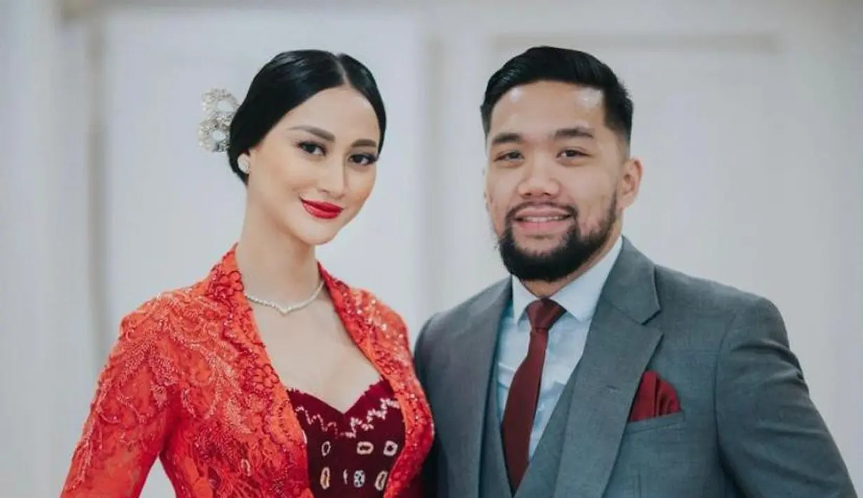 <p>Sedangkan sang suami mengenakan setelan suit abu-abu dengan dasi dan handkerchief warna merah.</p>