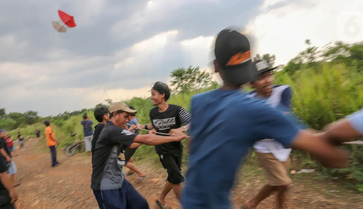 Warga menerbangkan layang-layang merah putih raksasa di kawasan Bambu Apus, Tangerang Selatan, Senin (17/8/2020). Layangan berukuran 10 X 9 meter yang diterbangkan oleh puluhan warga digelar dalam rangka memperingati HUT Ke-75 RI. (Liputan6.com/Fery Pradolo)