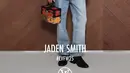 Jaden Smith hadir dengan atasan kemeja lengan balon motif kotak-kotak bergaris hitam dipadukan kalung layering dan celana denim panjang. Membawa tas kotak dan mengenakan sepatu pantofel berhak hitam. [dok. Louis Vuitton]