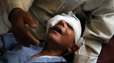 Seorang anak menangis kesakitan karena luka tembak di bagian mata akibat kerusuhan di Srinagar, Kashmir, Kamis (18/8). Sedikitnya lima orang tewas dan 20 lainnya mengalami luka parah akibat bentrok antara warga dan petugas keamanan. (REUTERS)