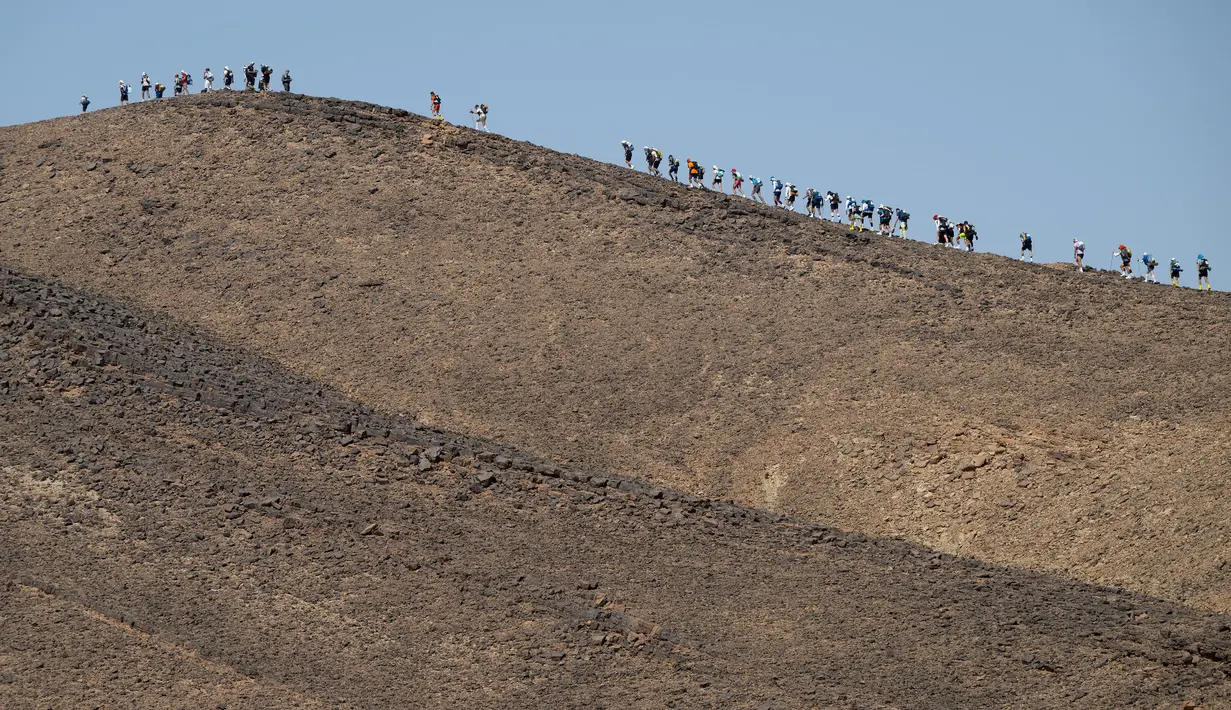 Sejumlah pelari berkompetisi pada stage kedua Marathon des Sables 2023 yang menempuh antara Oued Tijekht hingga Jebel El Otfal di Gurun Sahara, Maroko, 24 April 2023. Ajang yang berlangsung dari 21 April hingga 1 Mei 2023 tersebut diikuti oleh 1200 pelari dan akan menempuh 250 km. (AFP/Jean-Philippe Ksiazek)