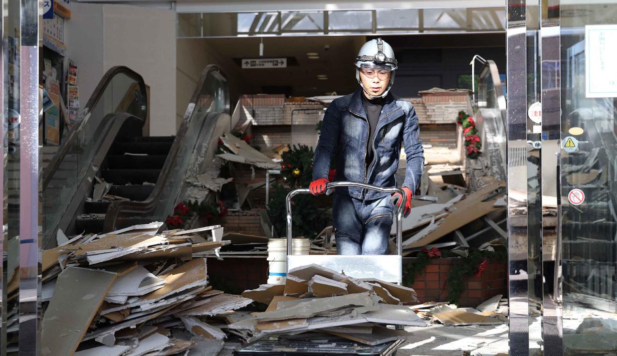 Otoritas meteorologi Jepang (JMA) memperingatkan kemungkinan besar akan terjadi sejumlah gempa susulan dalam beberapa hari ke depan. Tampak dalam foto, seorang pekerja membersihkan puing-puing di sebuah pusat perbelanjaan yang rusak akibat gempa bumi di Kota Hachinohe, Prefektur Aomori, Jepang, pada Selasa 9 Desember 2025. (JIJI Press/Japan OUT/AFP)