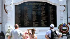 Para wisatawan asing berdiri di depan monumen Bom Bali 2002 saat upacara peringatan untuk menandai peringatan ke-22 di Kuta dekat Denpasar, Bali, pada Sabtu 12 Oktober 2024. (SONNY TUMBELAKA/AFP)