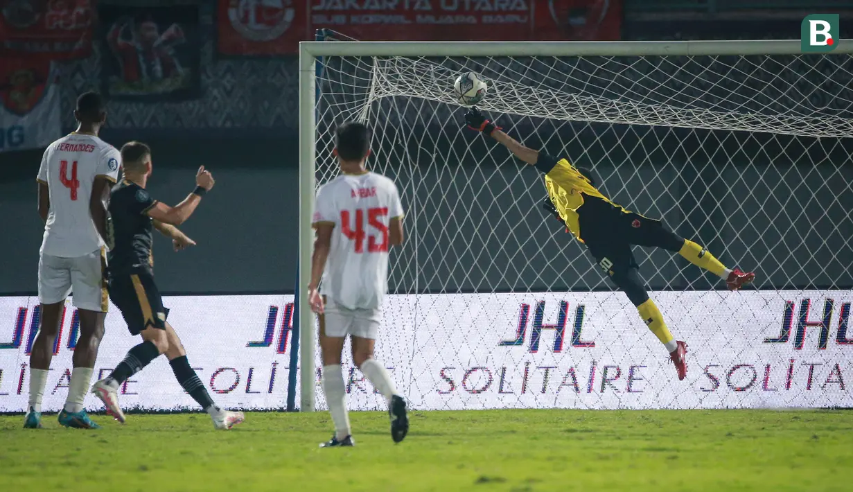 <p>Kiper PSM Makassar, M. Reza Arya Pratama berusaha menghalau bola hasil tendangan pemain Dewa United FC, Majed Osman Sobhi (kedua dari kiri) saat laga pekan ke-10 BRI Liga 1 2022/2023 antara Dewa United FC melawan PSM Makassar di Stadion Indomilk Arena, Tangerang, Kamis (15/9/2022). (Bola.com/Bagaskara Lazuardi)</p>