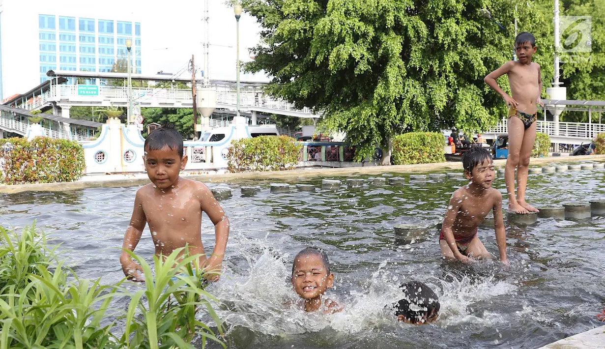 Anak-anak berenang di kolam air mancur penghias kawasan Pasar Baru, Jakarta, Selasa (29/1). Keterbatasan lahan bermain menyebabkan sebagian anak di Ibukota bermain tidak pada tempatnya, meskipun berbahaya bagi keselematan. (Liputan6.com/Immanuel Antonius)