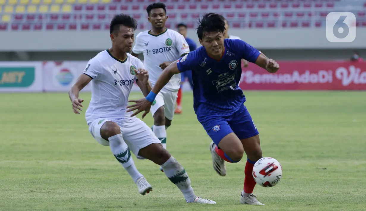 Bek Persikabo 1973 Andy Setyo Nugroho berebut bola dengan pemain Arema FC Feby Eka Putra pada laga Piala Menpora di Stadion Manahan, Solo, Minggu (21/3/2021). Kedua tim bermain imbang 1-1. (Bola.com/M Iqbal Ichsan)