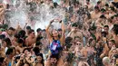 Seorang wanita membuat tanda hati dari tangannya saat berdansa di kolam selama Festival Arenal Sound di Pantai Burriana, Spanyol (2/8). Festival musik enam hari ini menampung sekitar 240.000 orang. (AFP Photo/Jose Jordan)