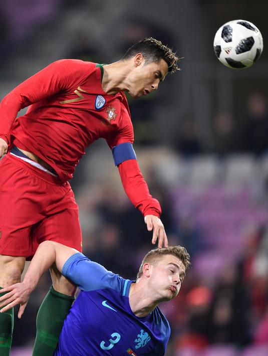 Penyerang Portugal, Cristiano Ronaldo berebut bola dengan bek Belanda, Matthijs de Ligt selama pertandingan persahabatan di stade de Geneve Stadium di Jenewa  pada 26 Maret 2018. Juventus diperkirakan membeli de Ligt senilai 70 juta euro ($ 80 juta) dari Ajax. (AFP Photo/Fabrice Coffrini)