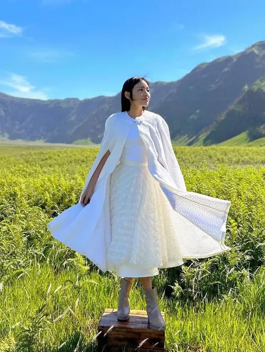 Cape tersebut dipadukan skirt putih cukup panjang, seeta sepatu bootsnya. Rambut panjang dibiarkan terurai tanpa poni. [@tiffanysoetanto]