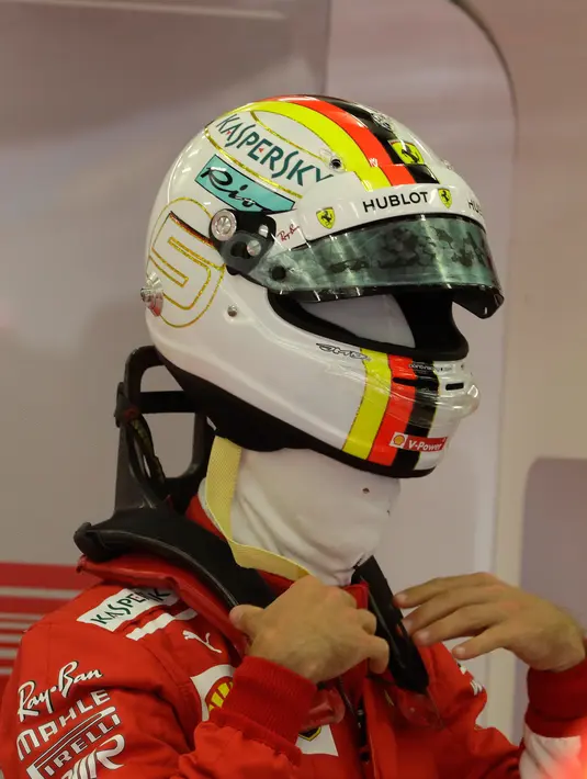 Pembalap Ferrari Sebastian Vettel dari Jerman memakai helmnya selama latihan bebas pertama di Sirkuit Internasional Formula One Bahrain di Sakhir, Bahrain, (6/4). Sebelumnya, Sebastian Vettel menjuarai balapan F1 GP Australia. (AP Photo/Luca Bruno)