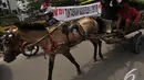 sebuah delman melintas di depan gedung KPK saat para pegiat anti korupsi melakukan aksi di Hari   Hari Anti Korupsi Sedunia, Jakarta, Selasa (9/12/2014). (Liputan6.com/Miftahul Hayat)