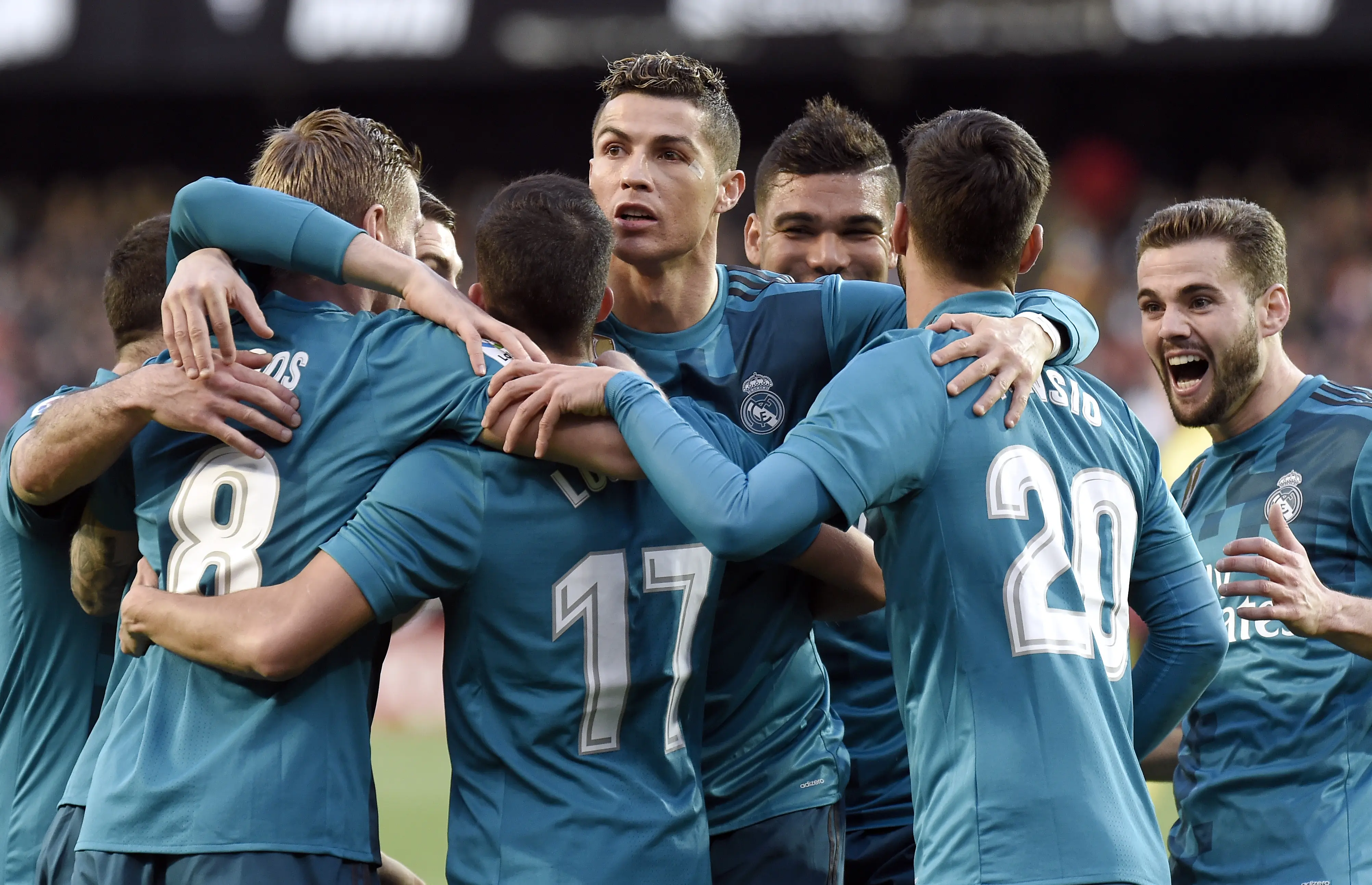 Cristiano Ronaldo (tengah) dan rekan-rekannya di Real Madrid merayakan gol Toni Kroos pada laga melawan Valencia di Mestalla, Sabtu (27/1/2018). (AFP/Jose Jordan)