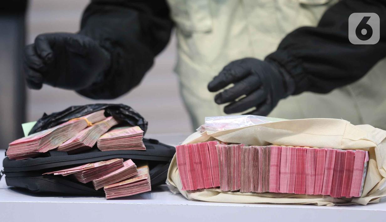 Barang bukti tersebut di antaranya beberapa dokumen, Barang Bukti Elektronik (BBE), beberapa pasang sepatu, serta uang tunai sebesar Rp 335,4 juta. Tampak dalam foto, tumpukan uang barang bukti terkait Operasi Tangkap Tangan (OTT) Bupati Tulungagung, Gatut Sunu Wibowo, diperlihatkan petugas di Gedung Merah Putih Komisi Pemberantasan Korupsi (KPK), Jakarta, Sabtu (11/4/2026). (Liputan6.com/Helmi Fithriansyah)