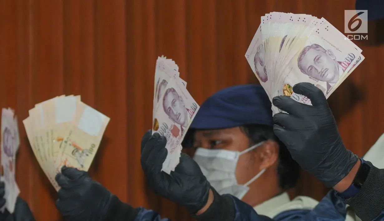 Petugas KPK menunjukkan barang bukti uang SGD 96.700 hasil OTT di Gedung KPK, Kamis (1/8/2019). KPK menetapkan Direktur Keuangan PT Angkasa Pura (AP) II Andra Y Agussalam sebagai tersangka kasus dugaan suap proyek pengadaan baggage handling system (BHS). (merdeka.com/Dwi Narwoko)