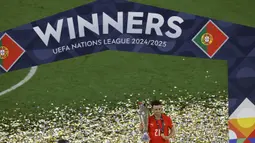 Diogo Jota, dilaporkan tengah berada dalam perjalanan bersama sang adik, Andre. Kecelakaan itu terjadi di provinsi Zamora, Spanyol. Tampak dalam foto, penyerang Portugal Diogo Jota berselebrasi dengan medali dan trofi setelah memenangkan pertandingan sepak bola final UEFA Nations League 2025 di Munich, Jerman selatan pada 8 Juni 2025. (Alexandra BEIER/AFP)