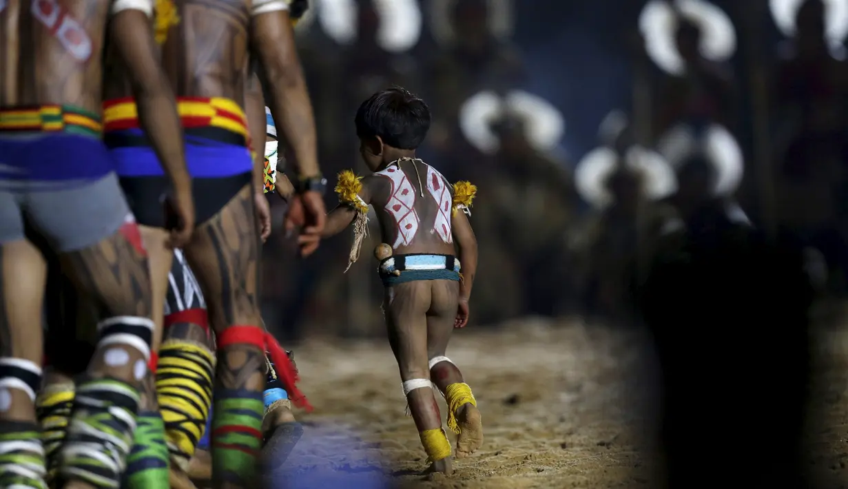 Seorang anak tampak ikut meramaikan upacara pembukaan Olimpiade bagi Masyarakat adat atau pribumi di dunia, Palmas, Brasil, Jumat (23/10/2015). Motto dari kejuaraan pada September nanti di Brasil adalah,"Kami semua Pribumi." (REUTERS/Ueslei Marcelino)