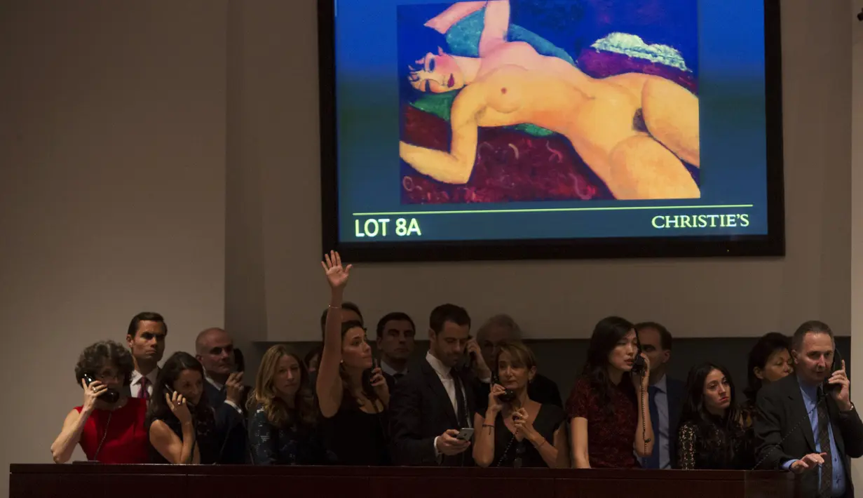 Pembeli melakukan tawaran saat lelang lukisan karya Amedeo Modigliani "Nu couche" berjudul "The Artis Muse", New York, USA (9/11). Lukisan karya Amedeo Modigliani ini terjual dengan harga $ 170,405,000.000 (sekitar 2 Triliun). (REUTERS/Andrew Kelly)
