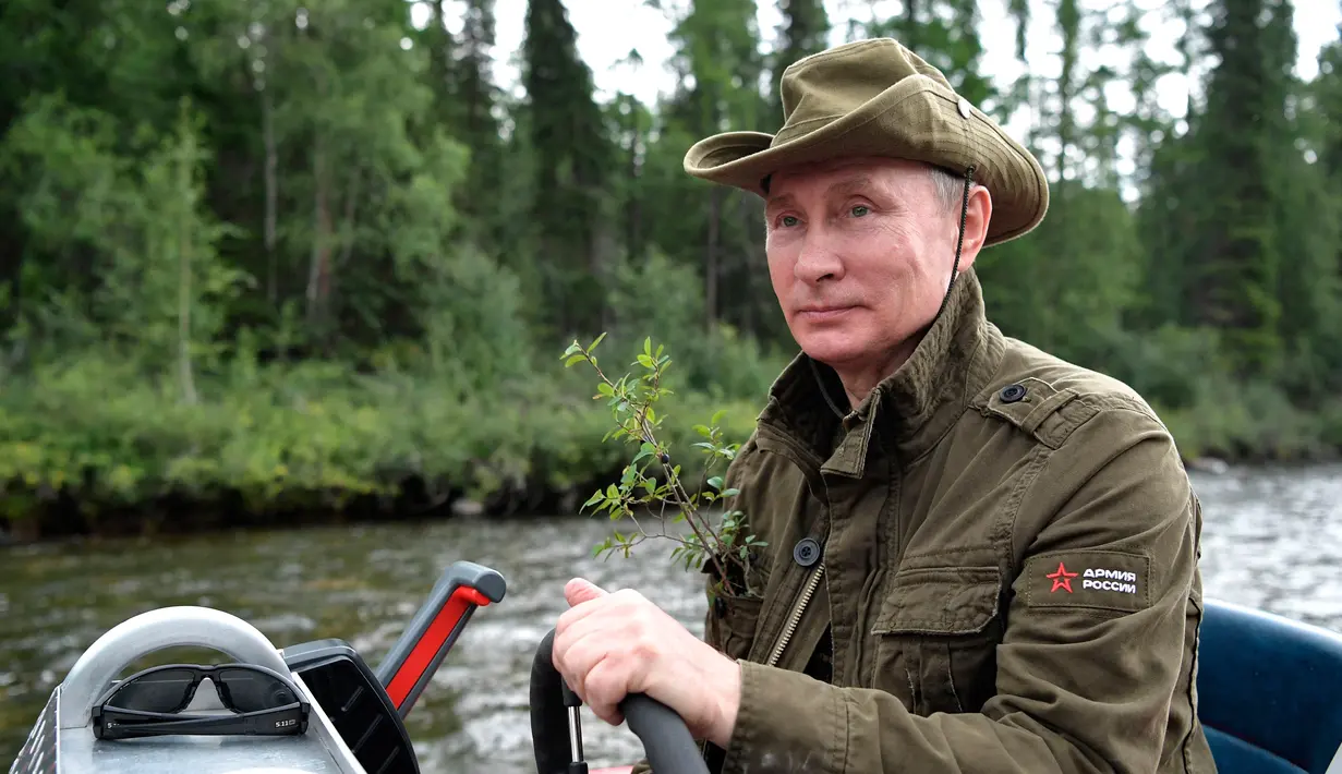 Presiden Rusia, Vladimir Putin mengendalikan sebuah kapal selama liburan mini di kawasan Siberia Tyva. Foto dirilis oleh biro pers Kremlin, pada 5 Agustus 2017. (Alexei Nikolsky / Sputnik, Foto Kolam Kremlin via AP)
