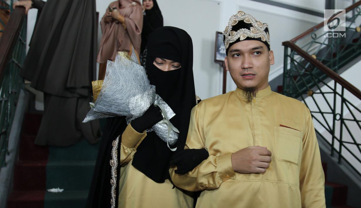 Pesinetron Egi John menggandeng istrinya, Kamilia Yasmin usai malangsungkan pernikahan di kawasan Cinere, Jakarta, Sabtu (1/7). Egi akhirnya resmi melepas status duda dan menikah untuk kedua kalinya dengan Kamilia Yasmin. (Liputan6.com/Herman Zakharia)