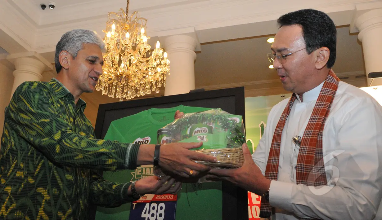 Presiden Direktur Nestle Indonesia, Rashid Qureshi memberikan parsel kepada Gubernur DKI Jakarta Basuki T Purnama usai konferensi pers Jakarta International 10k, di Balai Kota, Jumat (22/5/2015). (Liputan6.com/Herman Zakharia)