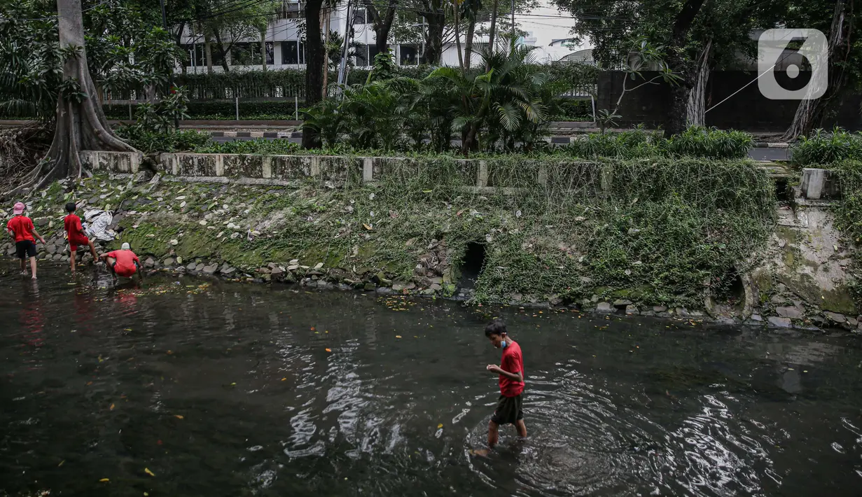 Sejumlah anak-anak mencari belut di anak kali menteng, Jakarta, Selasa (8/6/2021). Ruang bermain anak-anak di Jakarta kian terbatas. Terbatas lahan bermain membuat anak-anak Jakarta bermain ditempat yang tak semestinya demi mencari kesenangan. (Liputan6.com/Faizal Fanani)