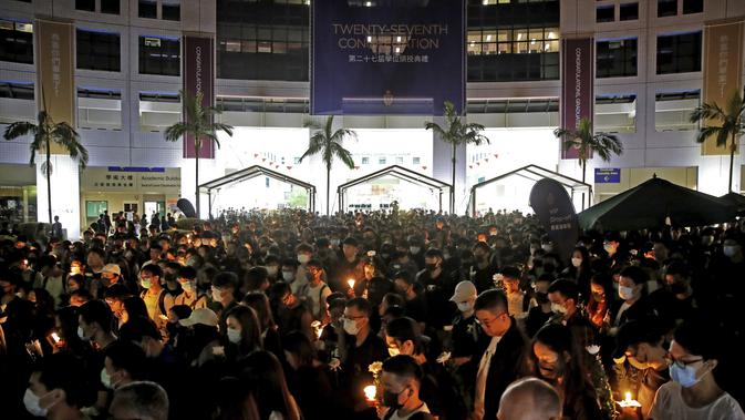 Para pengunjuk rasa menyalakan lilin memberi penghormatan kepada mahasiswa Alex Chow Tsz-lok yang tewas di Hong Kong (8/11/2019). Tewasnya Chow memicu kemarahan lebih besar terhadap pihak berwenang di wilayah China semi-otonom. (AP Photo/Kin Cheung)